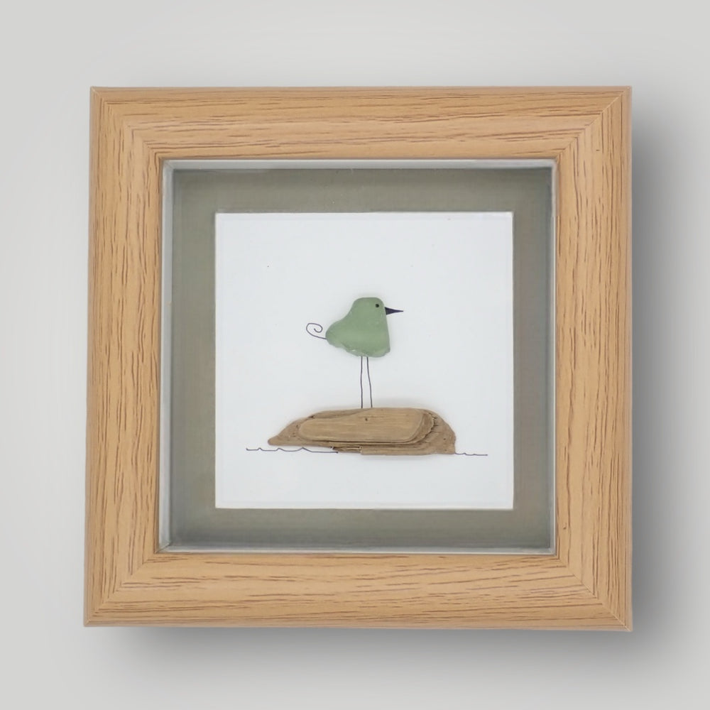 sea glass art picture of a bird standing on driftwood