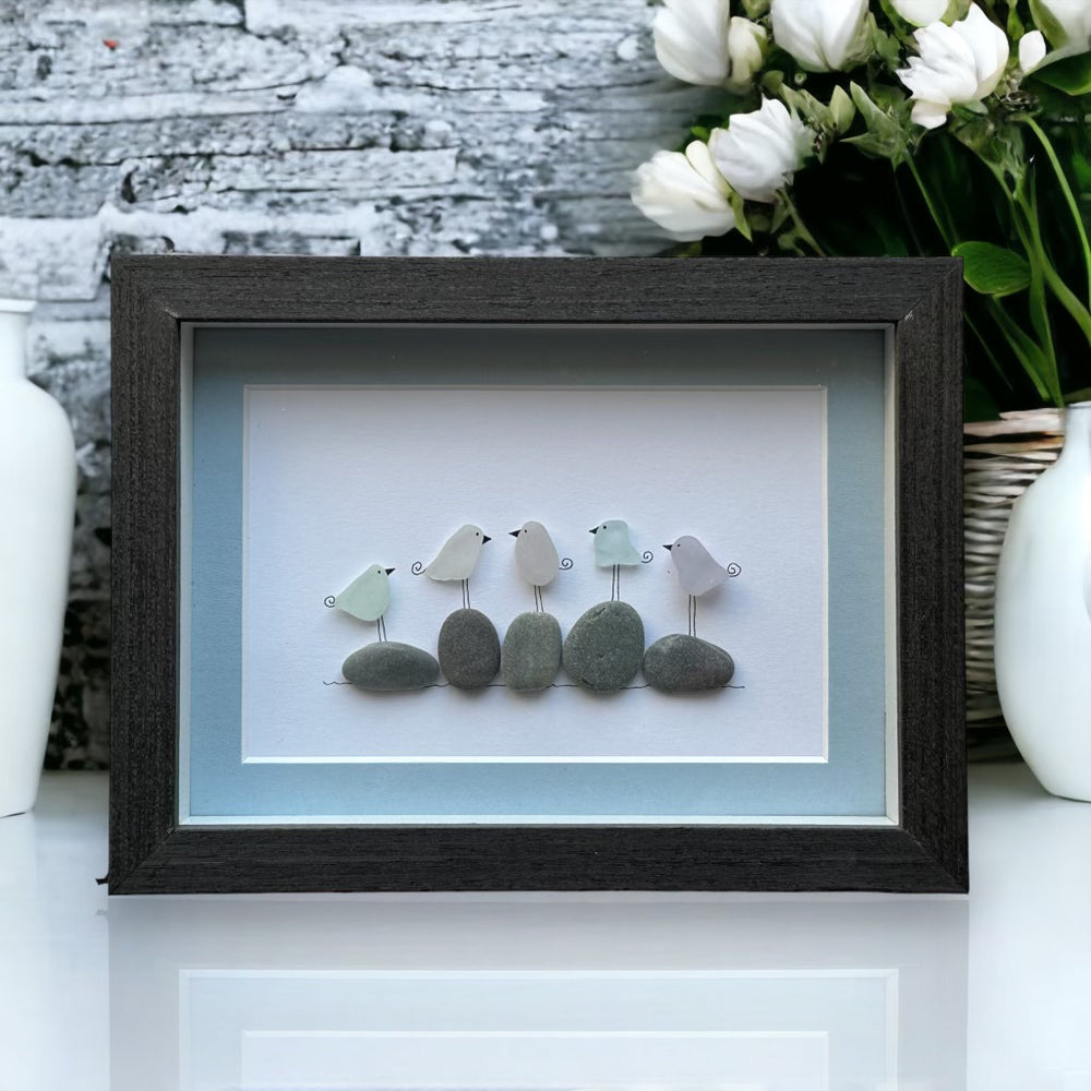 Imagen familiar de cinco pájaros de cristal marino sobre rocas