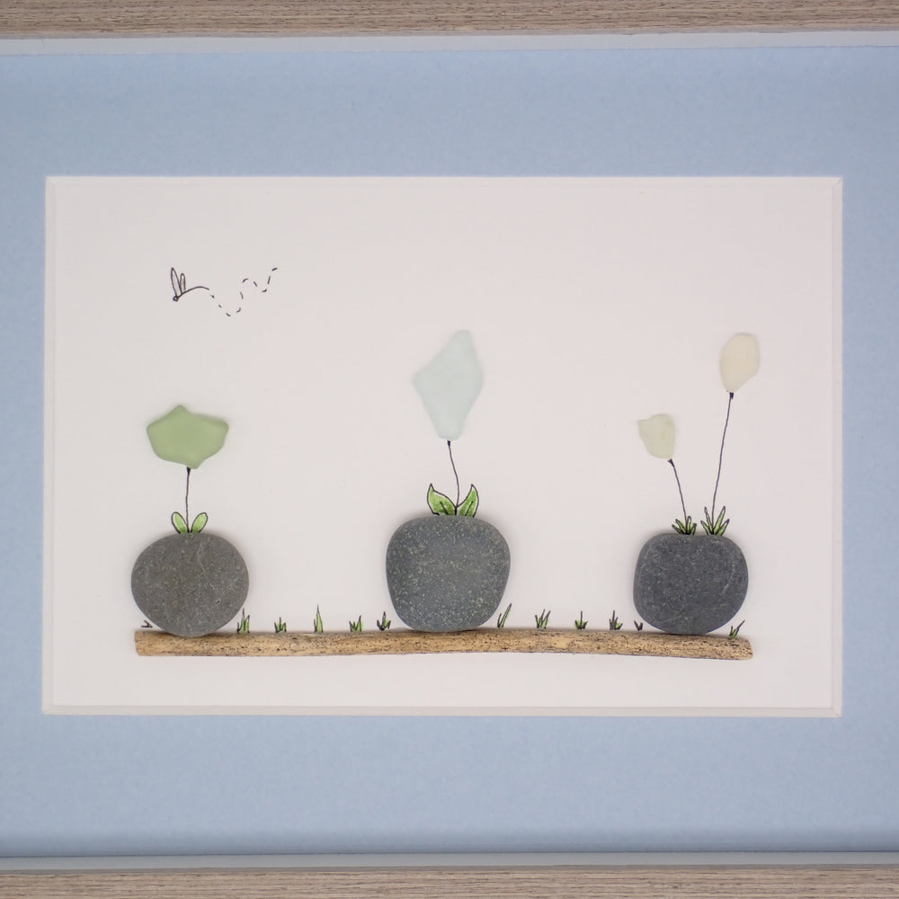 sea glass art features sea glass flowers potted in beach rocks