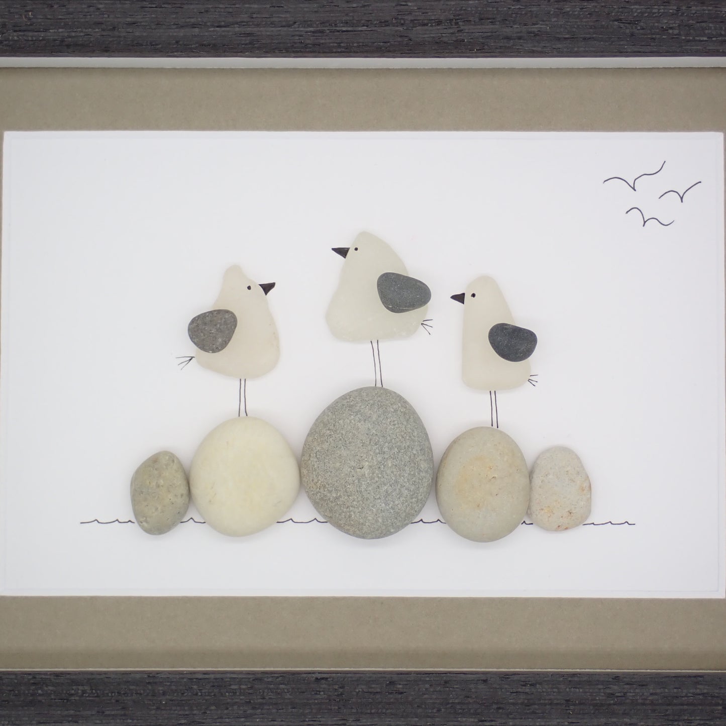 sea glass art features three sea gulls standing on beach rocks