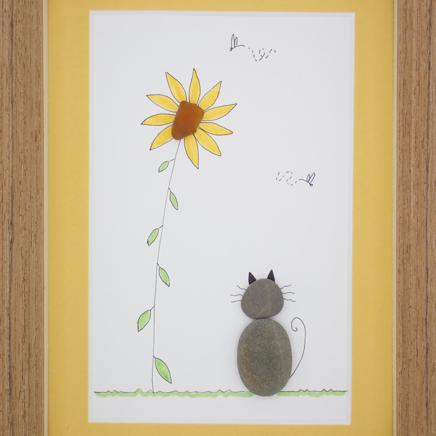 sea glass art features a cat sitting by a sea glass sunflower