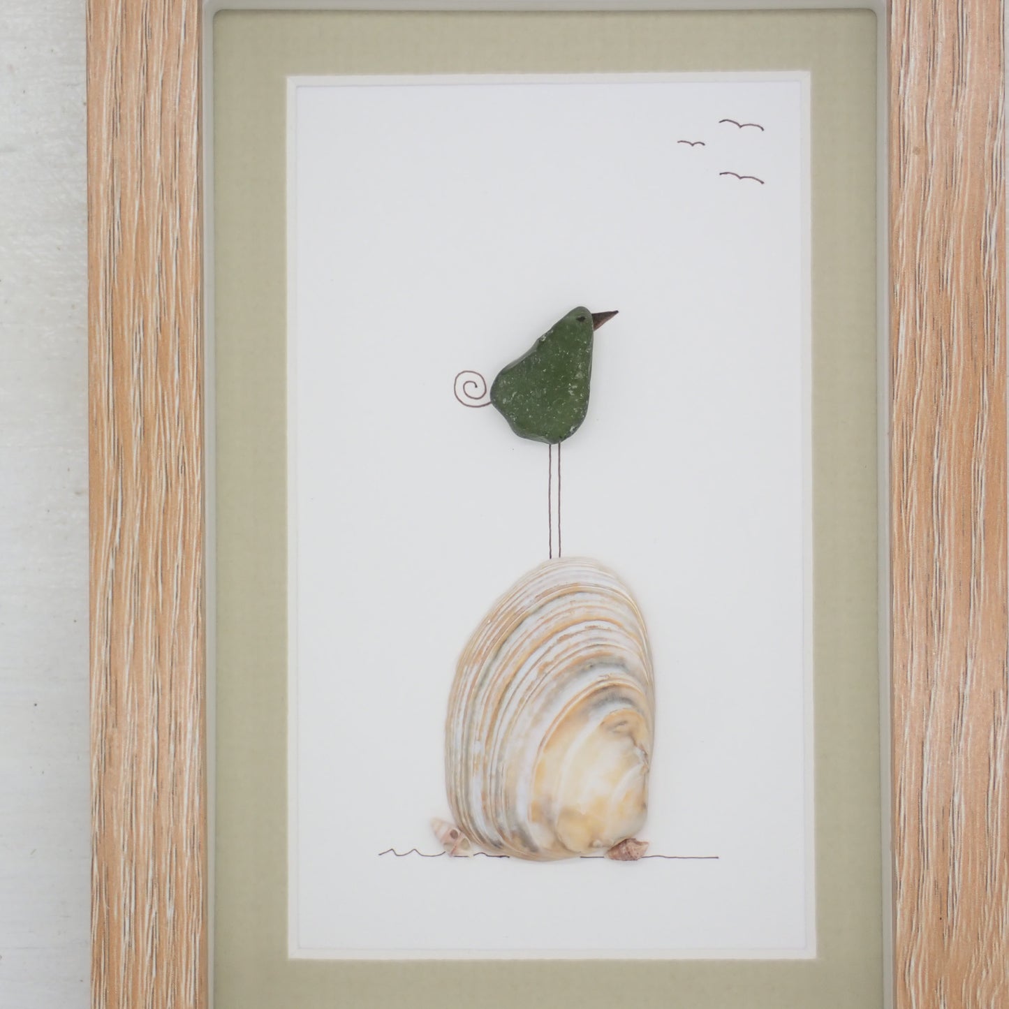 sea glass art features a sea glass bird standing on a clam shell