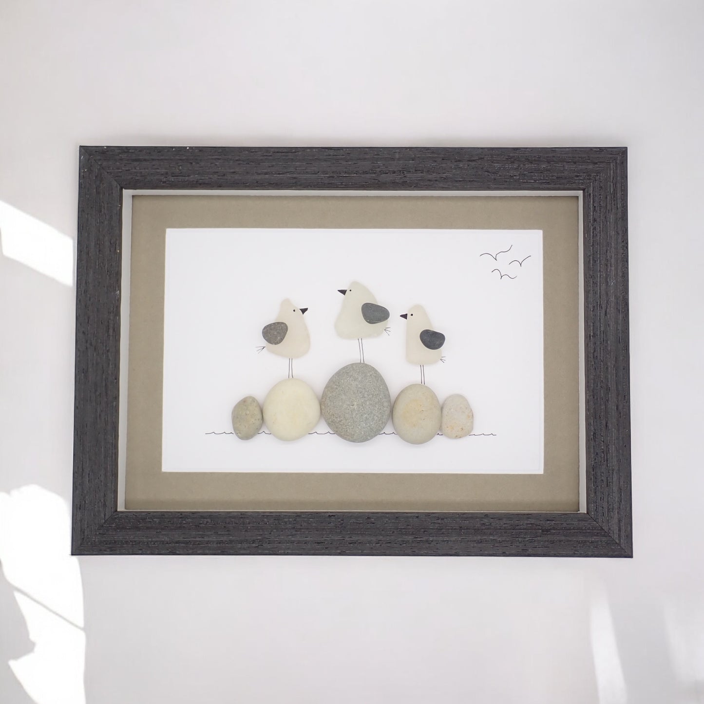 sea glass art features three sea gulls standing on beach rocks