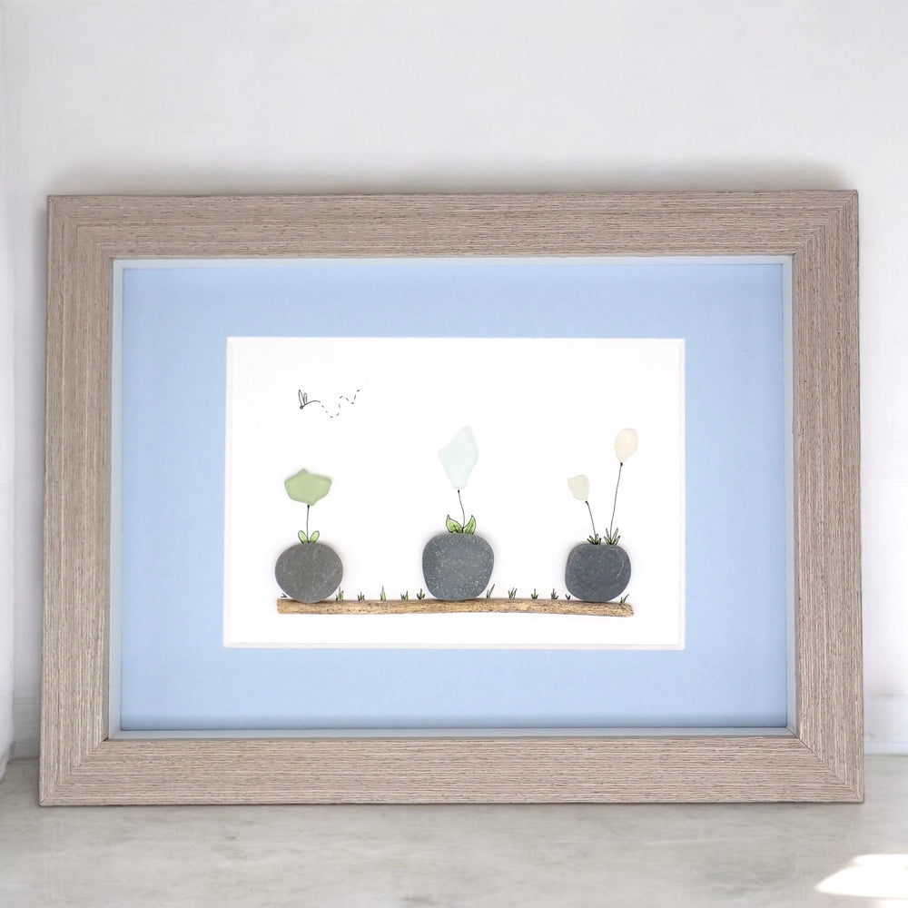 sea glass art features sea glass flowers potted in beach rocks